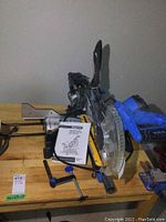 Overall view of Mastercraft saw on wooden table with manual and clamp