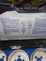 Photo of the inside lid of the hole saw cutting tips case with instructions in English and French, showing compatible sizes and usage guidelines.