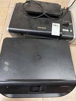 Top and front view of Lexmark and HP ENVY 4516 printers showing brand logos and device condition.