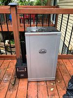 Front and side view of entire smoker unit with chip generator and protective cover nearby
