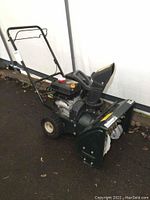 Side view of the Bolens 22-inch gas powered snow blower showing handlebar, engine, tires, and auger housing.