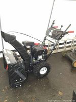 Side view showing chute, auger housing, wheels