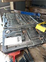 Black plastic case containing Allied socket and wrench set with multiple socket heads and ratchets visible, case open on workbench.