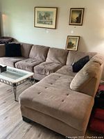 Left and chaise side view of the brown microfiber L shaped sofa showing tufted cushions and wood block feet.