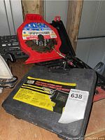 Closed carrying case for Home Handyman soldering gun kit and stacked dado blade set mounted on wall behind