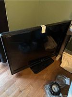 Full front view of the Toshiba REGZA flat screen TV showing the black bezel and stand on hardwood floor.