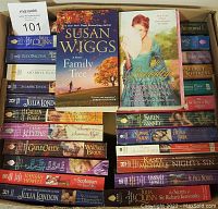 Box filled with 50 paperback romance novels, two books placed facing up showing covers 'Family Tree' by Susan Wiggs and 'A Scandalous Countess' by Jo Beverley