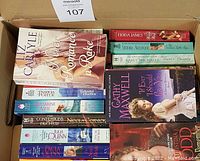 Photo of the spines and front covers of a selection of romance paperback books, showing titles and authors from various writers.