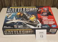 Photo of the original Electronic Battleship game box showing vibrant artwork and key game feature highlights.