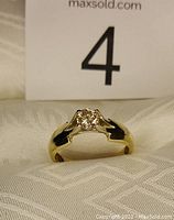 Front view of ring showing band shape and diamond center held by prongs