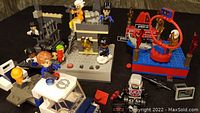 Photo of overall lot showing carnival cannon launch, Cityville prison break with jail cells, multiple mini-figures and accessories on dark surface