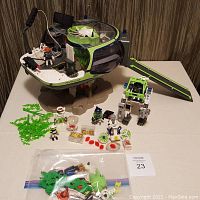 Overview photo showing the full set with base, figures, mech suit, and small accessories spread out in front.