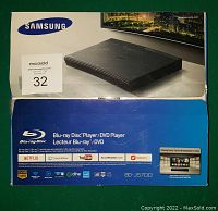 Photo of the unopened Samsung BD-J5700 Blu-ray/DVD player box showing front package with branding and streaming service logos, confirming model and features.
