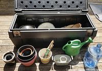 Shot showing open truck box with gardening tools inside and planters arranged outside in front of box