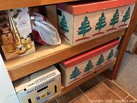 Two cardboard storage boxes with green tree pattern and Count box containing light bulbs