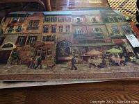 Floor mat showing a European street view with people walking and an outdoor café with umbrellas