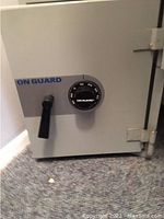 Photo of the closed On Guard safe showing combination lock, door handle, and hinges.