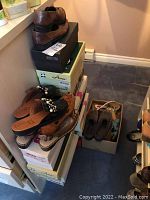 Photo of stacked shoe boxes and some slip-on shoes stacked on top, showing a variety of brands and styles.