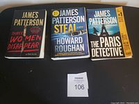 Photo showing the front covers of three James Patterson books: Three Women Disappear, Steal by Howard Roughan, and The Paris Detective. Books appear in good condition.