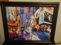 Framed colorful pop art picture featuring Marilyn Monroe in multiple poses set in a lively cityscape, showing overall artwork and frame condition.