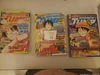 Photo showing three Shonen Jump animated comic books in great condition with One Piece main character Luffy on the covers.
