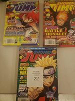 Photo of three Shonen Jump comic books featuring manga characters from Naruto, Bleach, and other series.