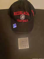 Front side of the black Ottawa Redblacks football hat showing embroidered team name, logo, and Reebok branding.