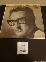 Vinyl record album cover for 'The Buddy Holly Story' showing close-up image of Buddy Holly with glasses and the title at the top.