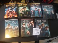 Photo shows seven Harry Potter widescreen DVD cases arranged in two rows, all appear in good condition.