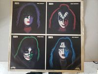 Four images showing different Kiss band members in iconic makeup.