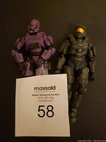 Photo showing front view of two Halo action figures, one purple Elite and one Master Chief in olive green armor.