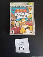 Photo showing the front cover of The Simpsons Road Rage game in an Xbox Platinum Hits case.