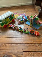 Shows full set of Sesame Street camper toy, Happy Meal train with multiple characters, and two bookends on wood floor