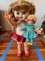 Front view of Buffy doll holding the smaller Mrs. Beasley doll, showing their outfits and facial details.