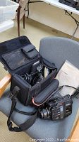 Canon H850 Hi8 video camera kit including the camera, battery, cables, and carrying case displayed on a chair.