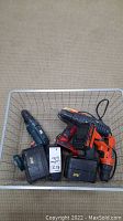 Basket with three cordless drills and batteries. Visible Skil Drive 18V and Mastercraft 24V battery with Black & Decker 9.6V drill.