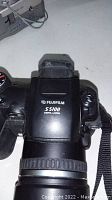 Top front view of the Fujifilm S5100 camera showing brand and model number, lens attached.