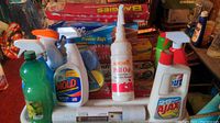 Photo of multiple cleaning products including Ajax, Clorox, Zout spray, mold removers, plastic wrap, foil, and Ziploc bags in background