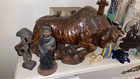 Various figurines including brown bull, robed male figure, figure with umbrella
