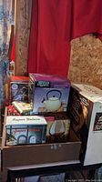 Lot items stacked in open box showing several boxed items including the whistling kettle box and cognac glasses box