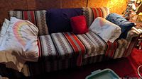 Full view of sofa with pillows and blankets covering it
