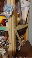 Side view of beige metal shelving unit with contents removed, shows vertical support beam with bolt details.