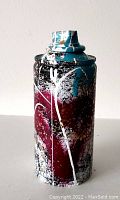 Front and side views of an original street art spray paint can sculpture by artist TedyZet. Shows detailed paint layers and signature on the can surface.