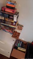 Stack of assorted board games including Codenames, Coup, Wow You're Good, Mancala, Lord of the Rings, Cranium, La Cosa