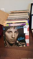 Stack of LP vinyl records with Bruce Springsteen's The River album cover facing front.