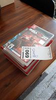 Stack of video game cases showing Nintendo Switch and PlayStation 3 games including NBA 2K20 and Skyrim.