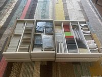 Three long white boxes filled with a large quantity of Game of Thrones LCG cards sorted and boxed. Includes some plastic sleeves and deck boxes visible.