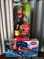 Two Barbie dolls in original boxes, one with skateboard and helmet, the other with floatation accessories and Coca-Cola branding