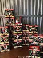 Multiple Coca-Cola holiday ornaments including polar bears and Santa Claus in green and red display boxes with Christmas tree-shaped window.