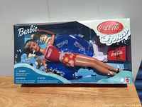 Full view of the Coca-Cola Splash Barbie in original retail packaging showing doll and cooler accessory inside.